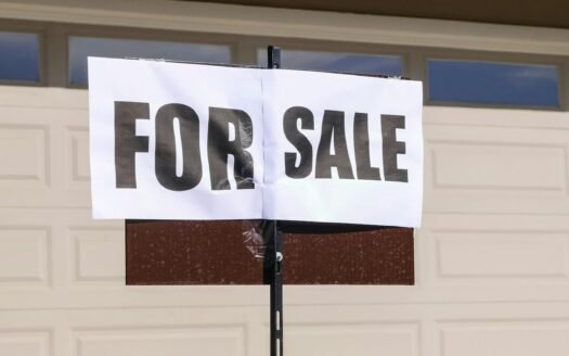 For sale sign in front of a house representing the sticky seller effect in the property market